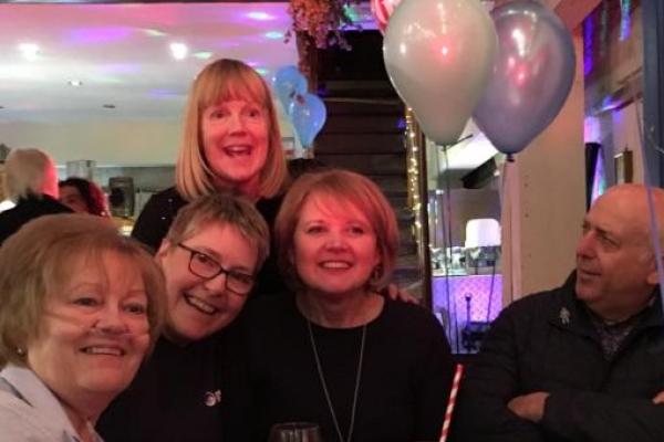 Four women and a man enjoying a birthday party fundraiser