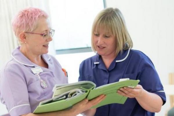 Two nurses discussing patient notes in a chemotherapy unit