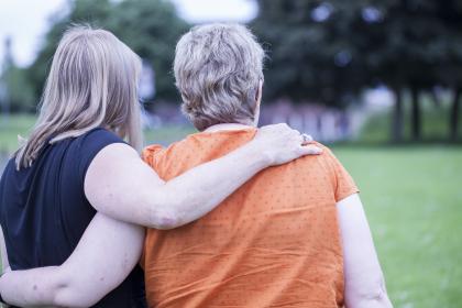 A woman with her arm around the back of another woman 