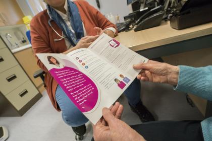 Close up of a woman holding an open Target Ovarian Cancer information leaflet