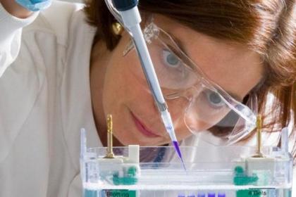 Close-up of a researcher wearing protective goggles while using equipment in a lab