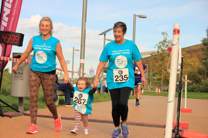 Jo with her daughter Chloe and granddaughter Lilah crossing the finish line at the Ovarian Cancer WalkRun 2018