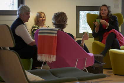 People sitting in comfortable chairs and talking at a cancer support centre