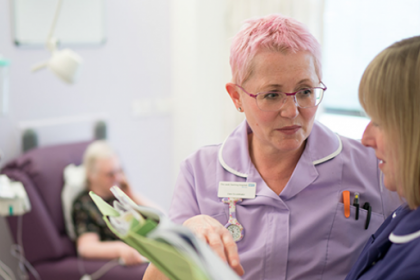 Two nurses discuss patient notes in a chemotherapy unit