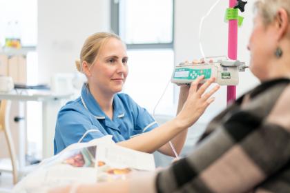 A nurse looking at a woman with ovarian cancer during treatment