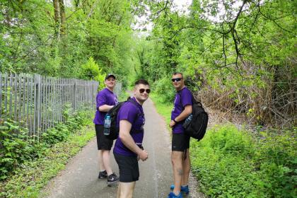 Three Target Ovarian Cancer fundraisers wearing purple t-shirts walking to raise money