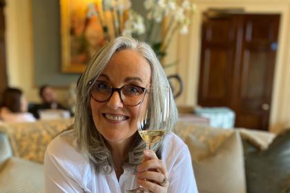 Helen wearing glasses and holding a glass of wine