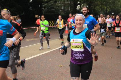A Target Ovarian Cancer fundraiser at the Royal Parks Half Marathon running and waving