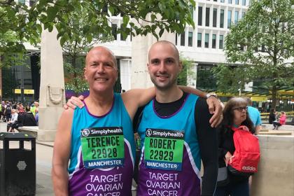 Two Target Ovarian Cancer fundraising in running vests with their arms around each other