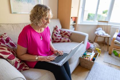 Woman on sofa looking at a laptop