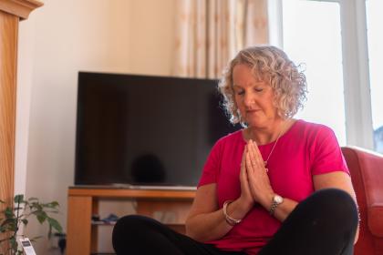 Woman crossed legged, eyes closed doing yoga
