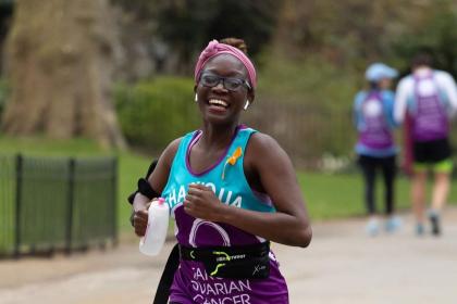 Shaniqua running in a London park taking on Run for Mum wearing her Target Ovarian Cancer running vest