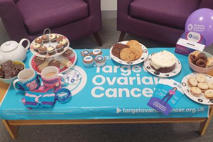 A photo of cakes, tea and Target Ovarian Cancer branded materials displayed on a table