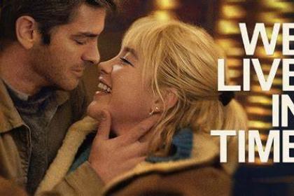 The poster for the film We Live in Time - it features a man and woman looking at each other closely and smiling