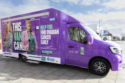 A photo of a purple van which has the words This Van Can on the side and photo of two women