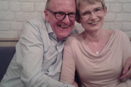 A photo of Stephen and Julie with their arms round each other smiling together