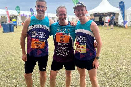 Three men at the Great North Run all smiling and wearing Target Ovarian Cancer running vests