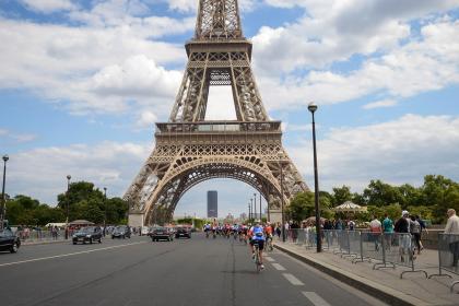 People cycling under the Eiffel tower. 