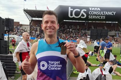 A male supporter smiling at the Amsterdam Marathon 2025