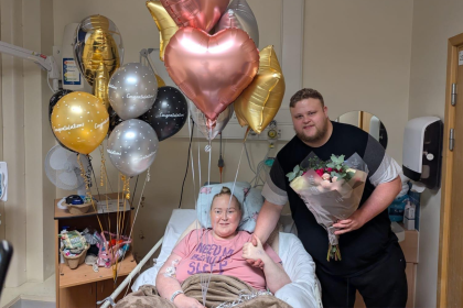 Edd and his wife Sophie smiling after Edd proposed, surrounded by balloons in hospital.