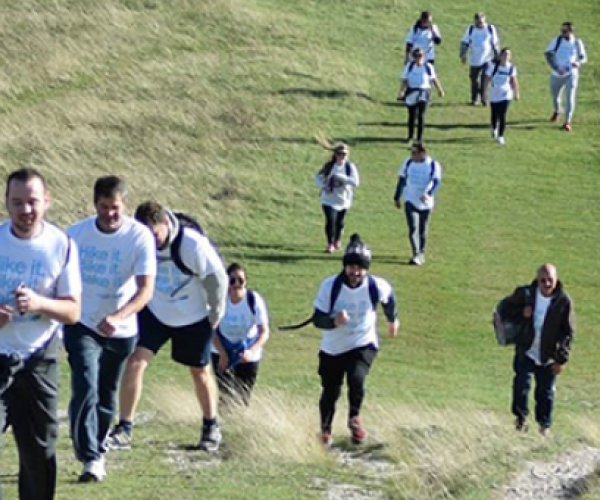 A team of people walking up a steep hill as part of the Chiltern Three Peaks Challenge