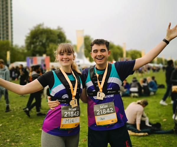 Male and Female supporter smiling and waving at Royal Parks Half Marathon 2024