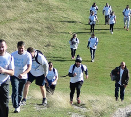 A team of people walking up a steep hill as part of the Chiltern Three Peaks Challenge