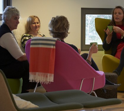 People sitting in comfortable chairs and talking at a cancer support centre