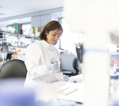 A female ovarian cancer researcher smiling while working in a lab