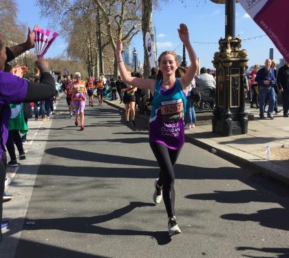 A Target Ovarian Cancer fundraiser running and waving to crowds