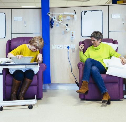 Two women laughing during chemotherapy