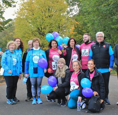 A group of fundraisers at the Ovarian Cancer Walk|Run holding balloons and smiling at the camera.JPG