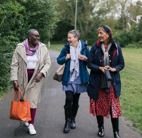 Three women walking in the park laughing and chatting