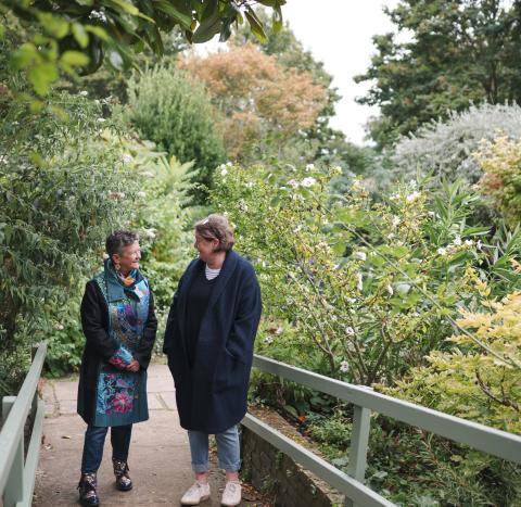 Two women walking through a park