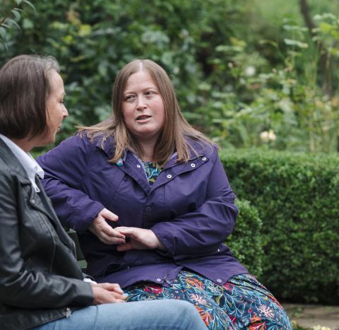 Two women on a bench talking