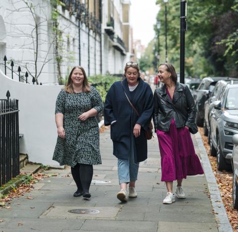 3 women walking down a street