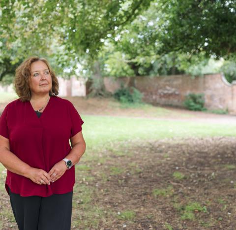 Woman outside looking up towards trees