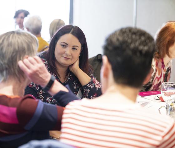 Women sat down at a table talking to each other during a Target Ovarian Cancer support event