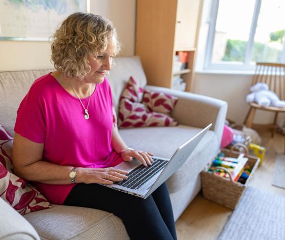 Woman on sofa looking at a laptop