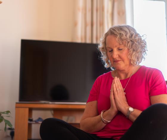 Woman crossed legged, eyes closed doing yoga