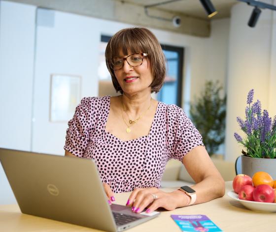 A woman sitting at the table on her laptop