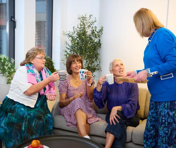 Four women sitting having tea together