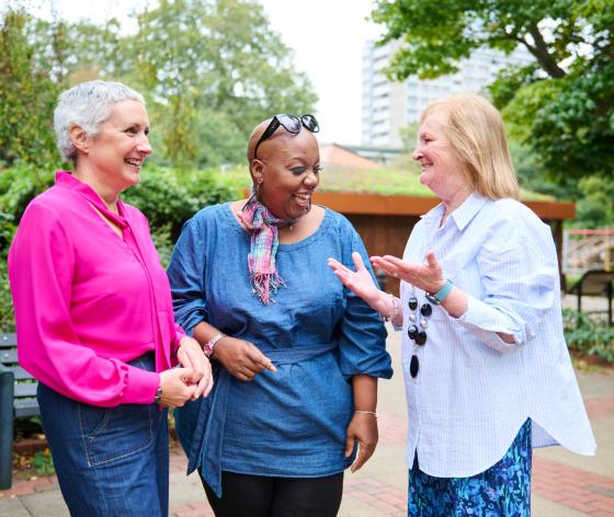 Three women standing together laughing
