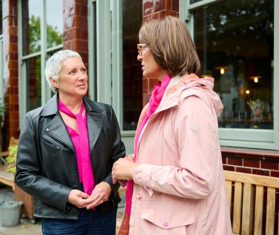 Two women chatting standing outside together
