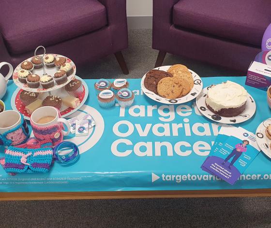 A photo of cakes, tea and Target Ovarian Cancer branded materials displayed on a table