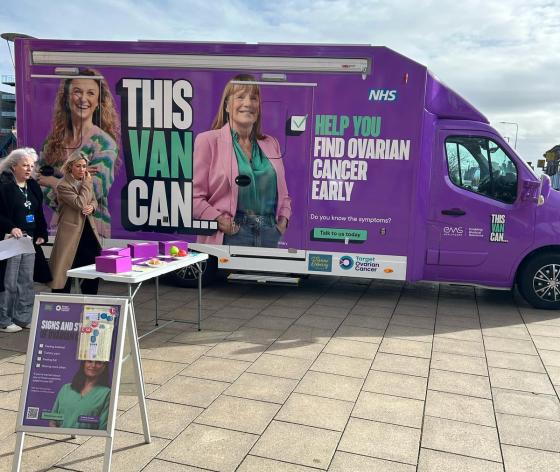 A photo of a purple van which has the words This Van Can on the side and photo of two women