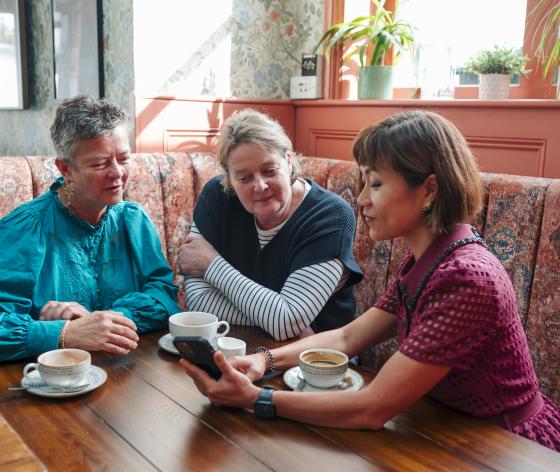 Three women looking at one phone