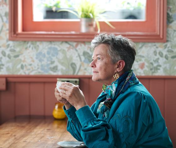 A woman sat at a table, drinking coffee