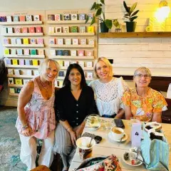 A photo of three women sitting in a cafe all smiling whilst attending a support group to meet other women with an ovarian cancer diagnosis