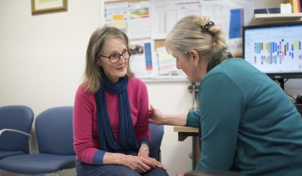 A woman is comforted by a GP in the GP's office